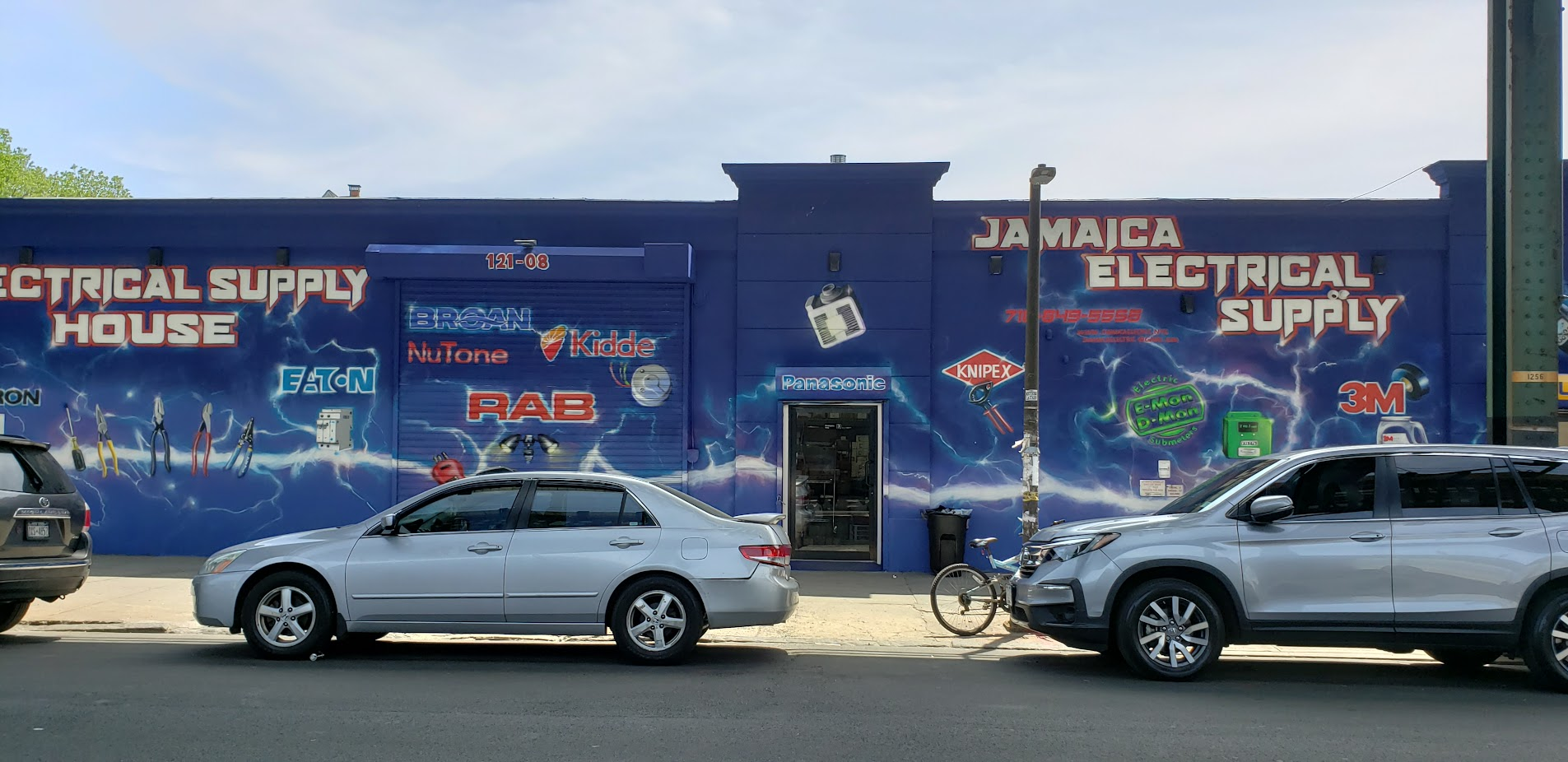 Brands painted across the Jamaica Electrical Supply storefront — Eaton, RAB, Broan, NuTone, Kidde, Knipex, 3M