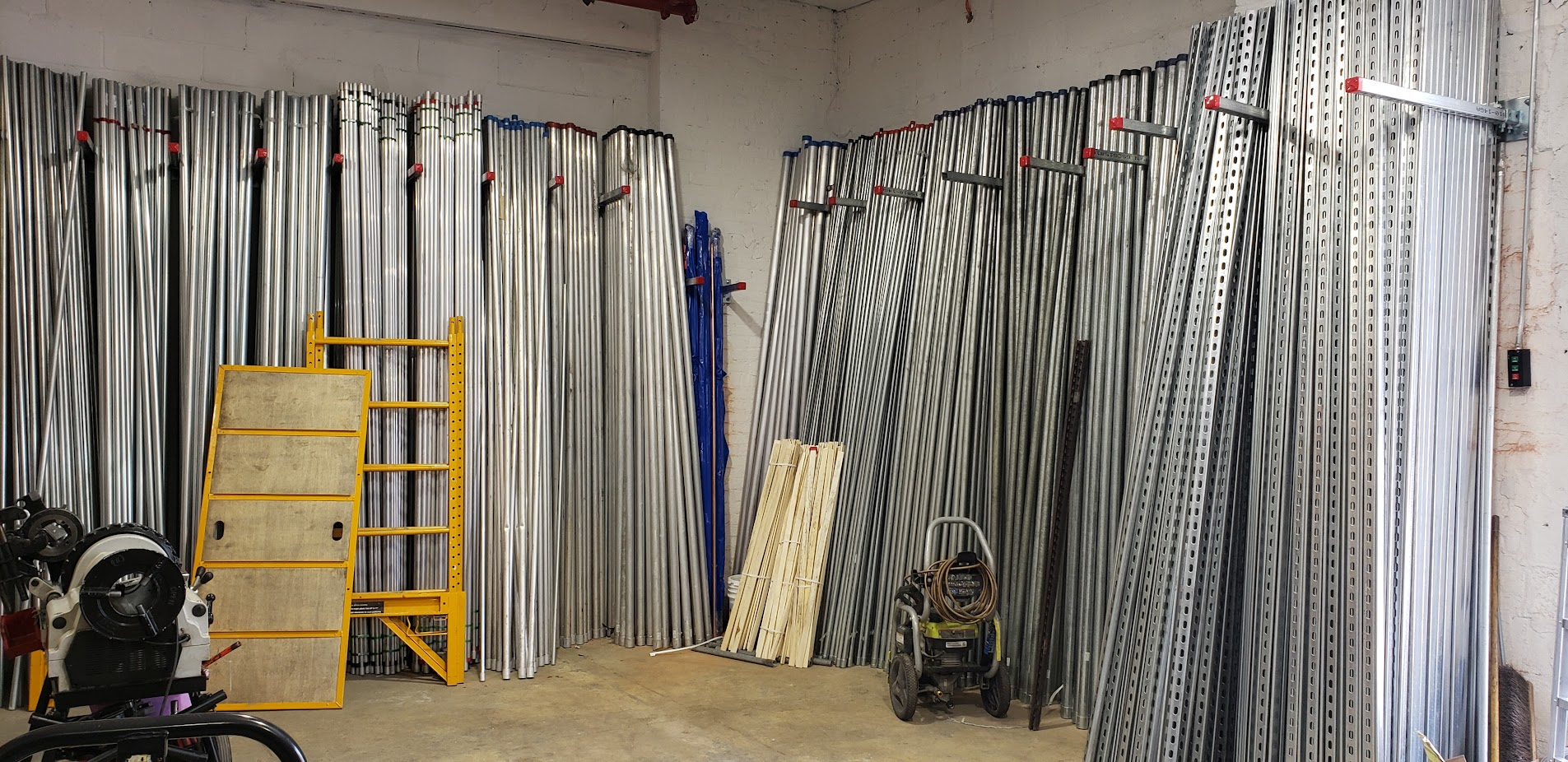 Warehouse aisle stacked with EMT, rigid conduit, strut and pipe